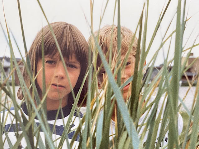 Ein Mädchen und ein Junge schauen durch Schilf